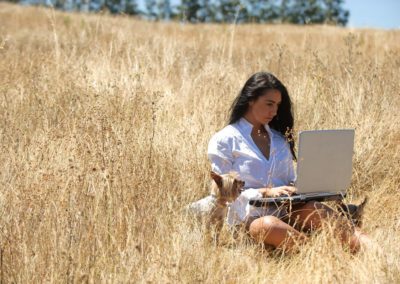 Woman working on a laptop in Texas Hill Country field